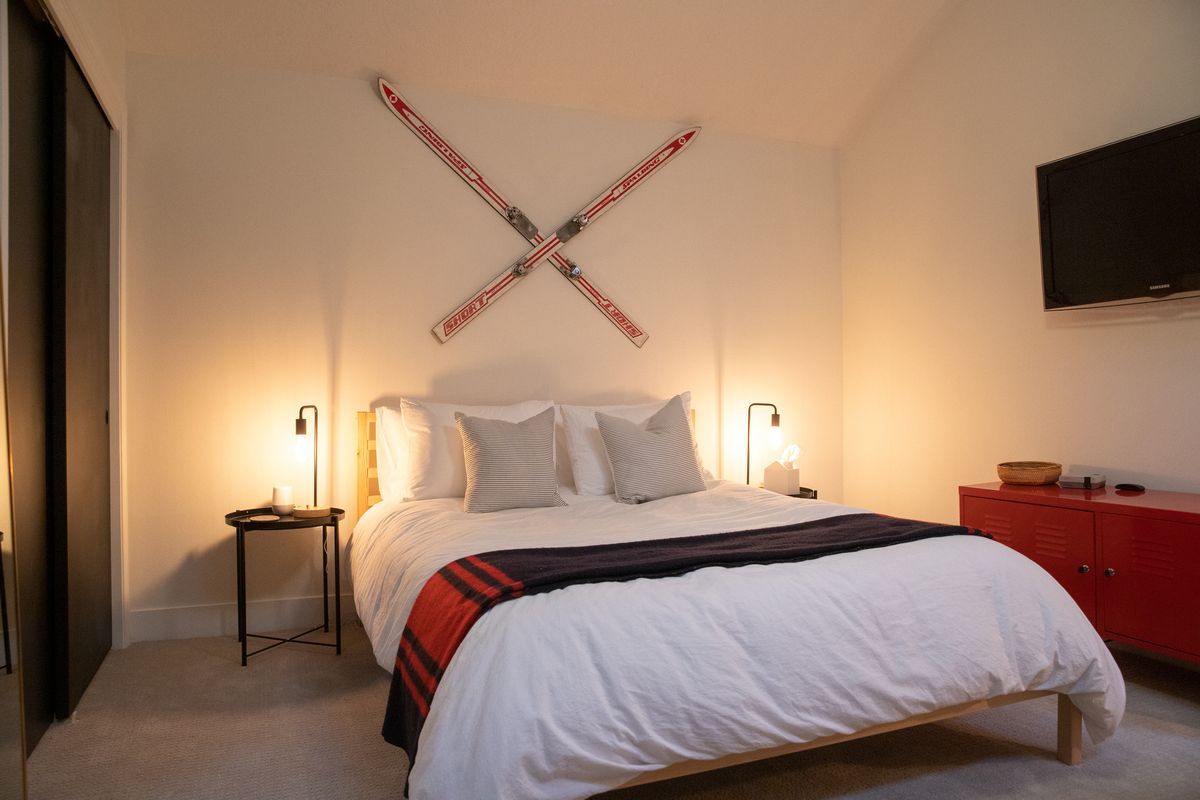 Bed with crossed vintage skis on the wall