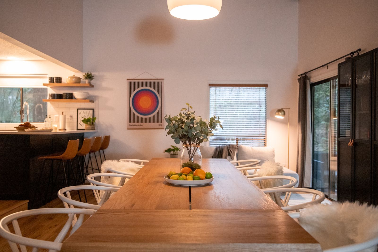 Long wood dining table with white wishbone chairs