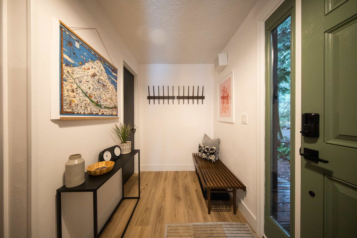 Entry hall with a bench, coat hooks and a map of Mt. Hood