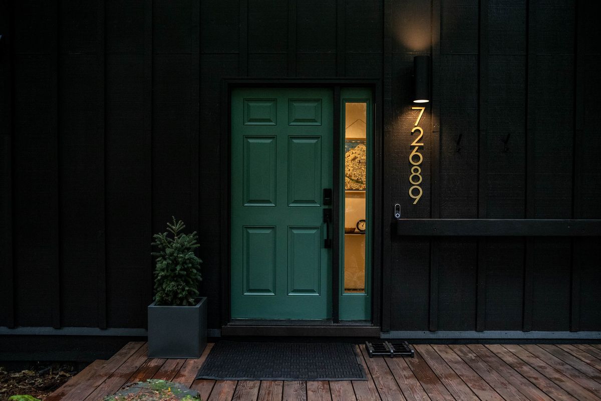 Teal front door on the black cabin