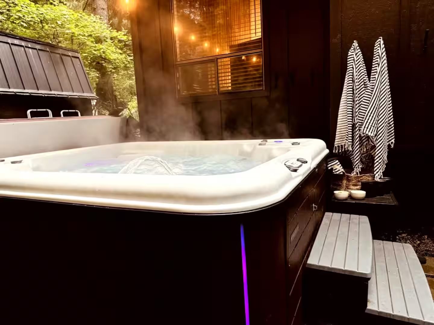 Steam rising from the private hot tub under string lights