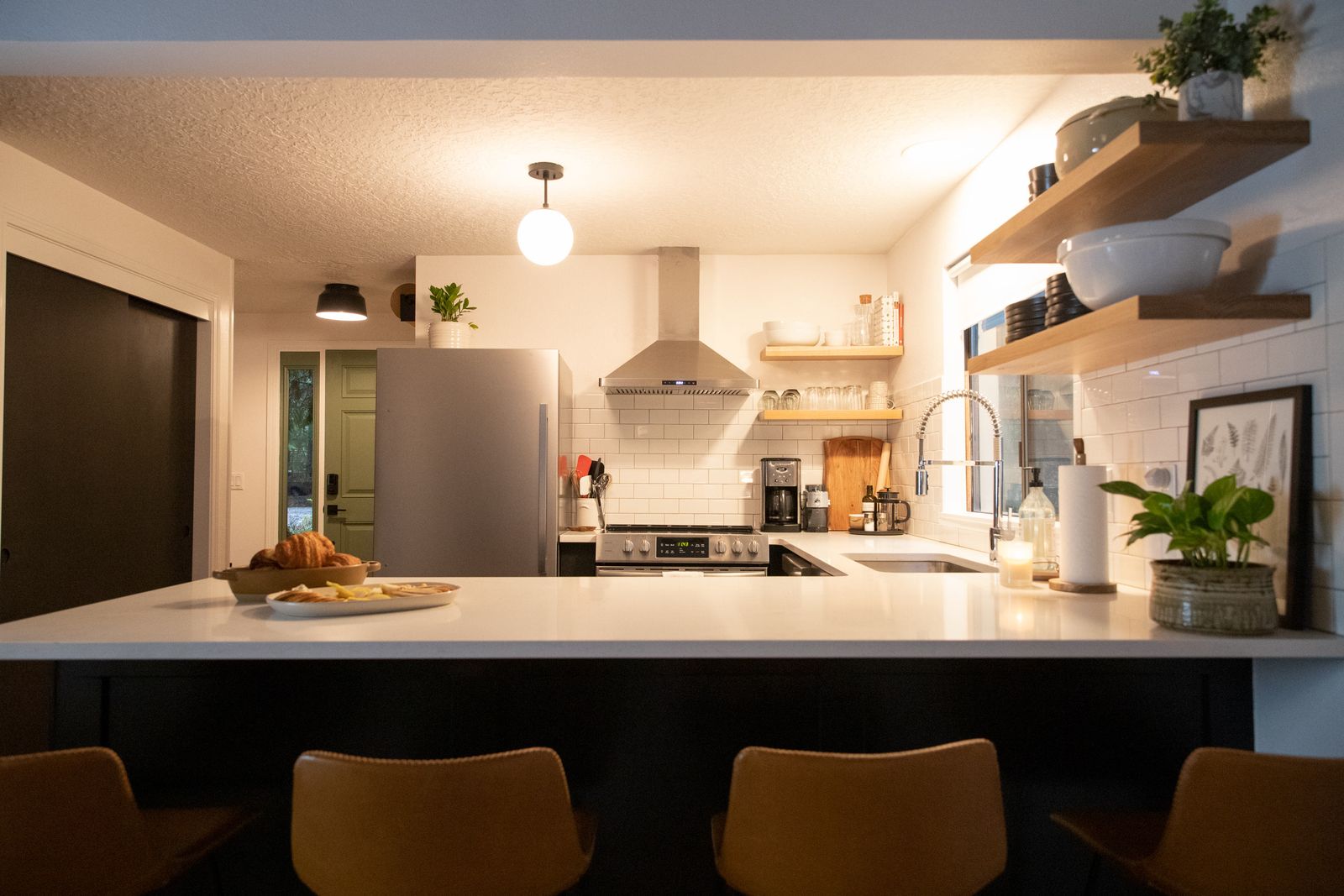 Kitchen with a breakfast bar, open shelves and stainless appliances